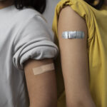 dua wanita setelah vaksin dengan plaster di tangan